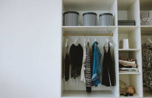 Blue and Black Jackets Hanged on White Wooden Cabinet
